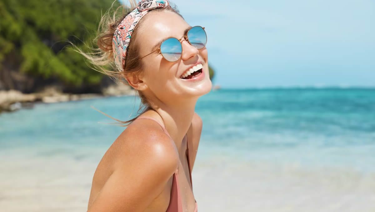 Mujer sonriendo en la playa (Foto: Freepik)
