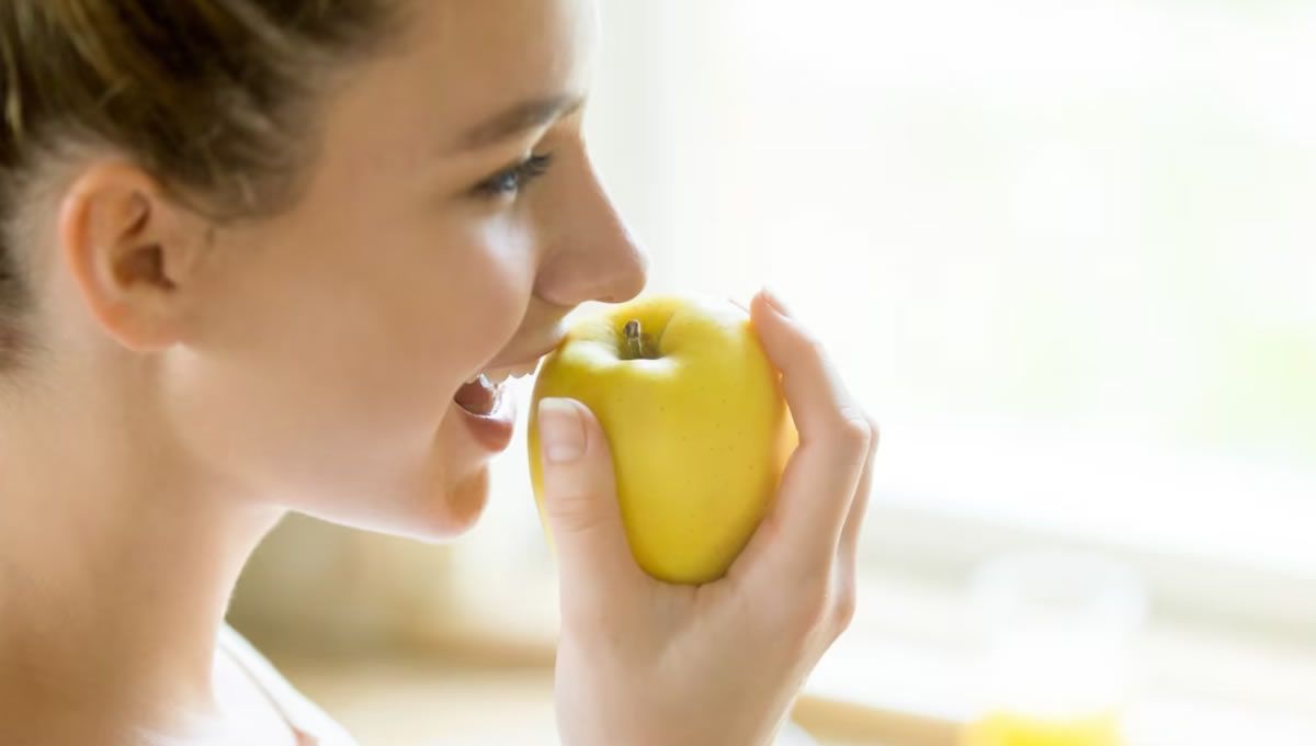 Mujer comiendo una manzana (Foto: Freepik)