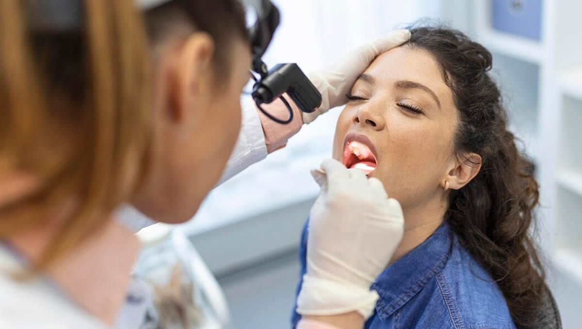 Dentista explorando la lengua a un paciente