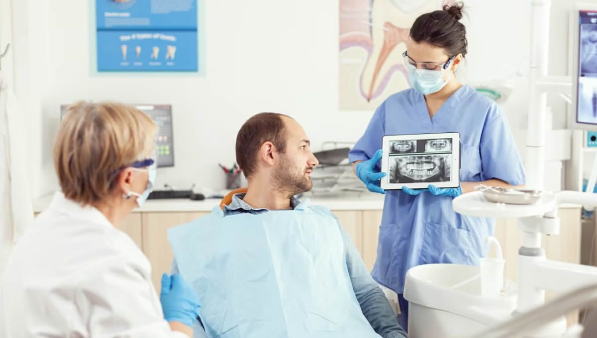 Consulta dental con paciente al que le muestran radiografía para valoración de densidad ósea (Fuente: Freepik)
