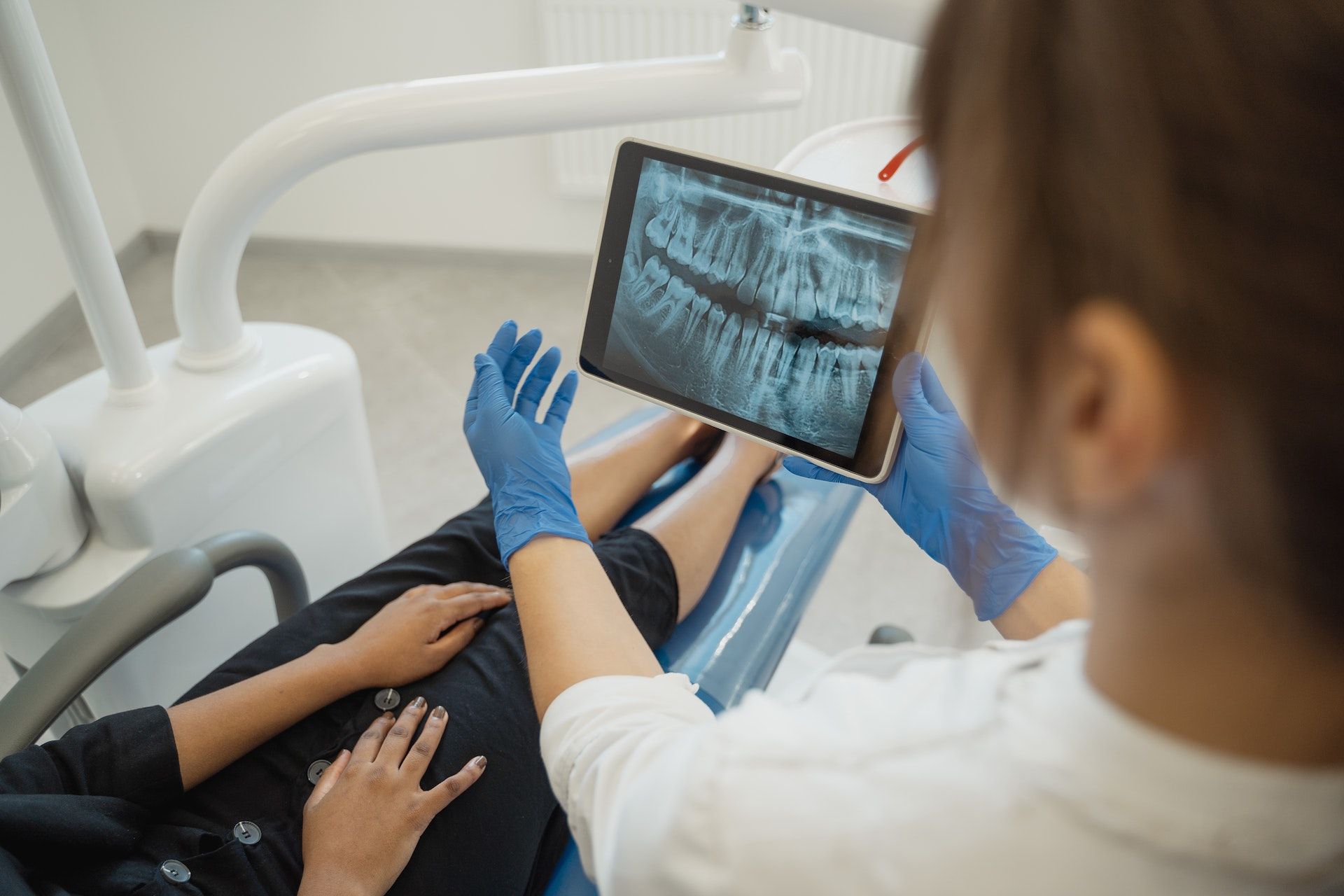 Dentista mostrando radiografia de la boca al paciente (Fuente: Centro Oncológico Integral Lineberger de la UNC)