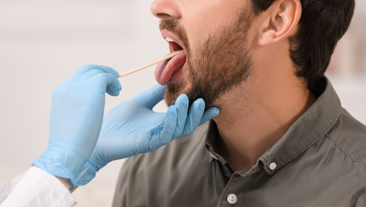 Odontólogo realizando una exploración de la boca a un paciente (Fuente: Canva)