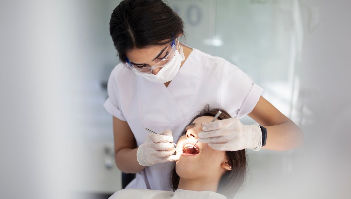 Higienista dental atendiendo a un paciente (Fuente: Canva)