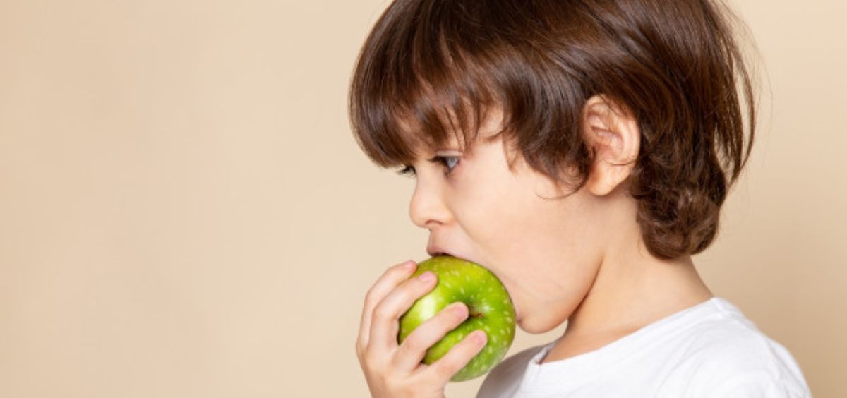 Niño comiendo fruta (Foto. Freepik)