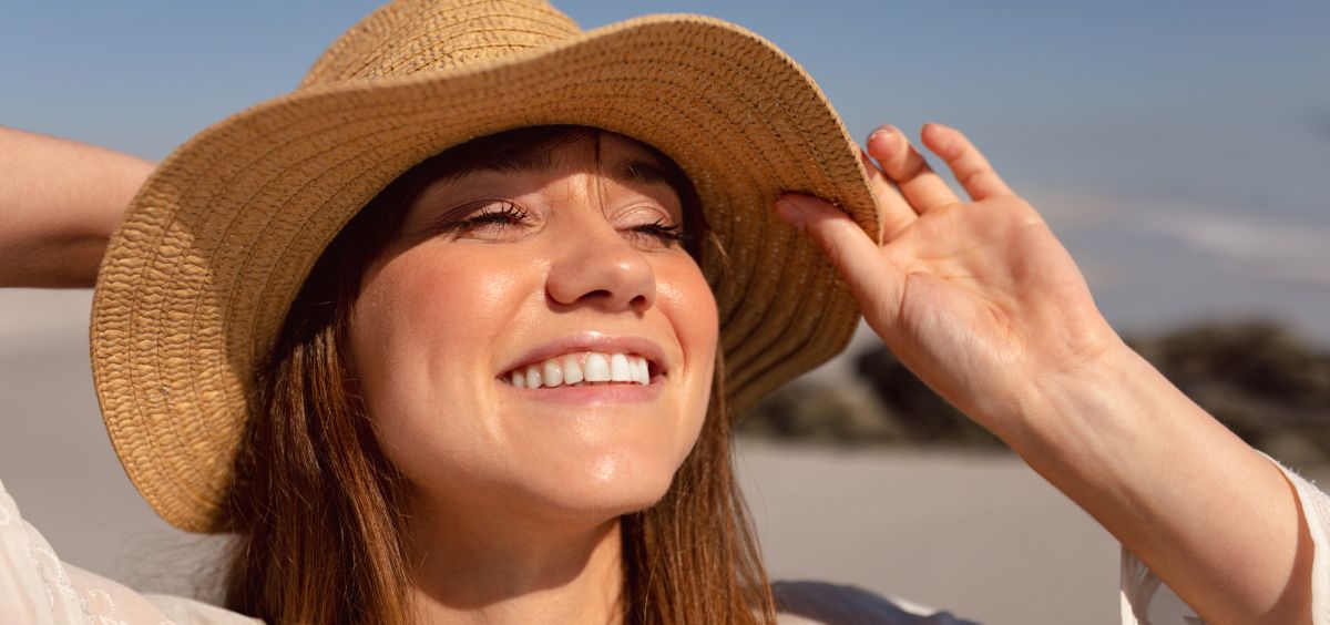 Mujer con sombrero de paja mirando al sol (Foto. Freepik)