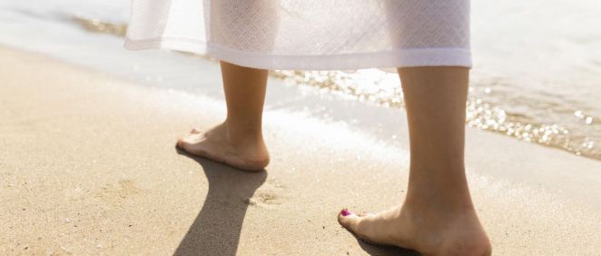 Pies de mujer caminando por la playa (Foto. Freepik)