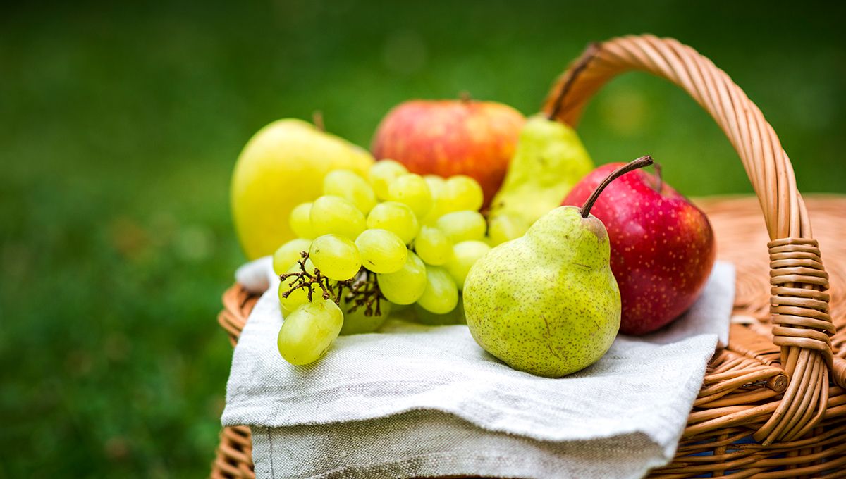 Manzanas, peras y uvas sobre una cesta de mimbre (Foto. Freepik)