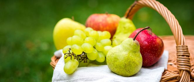 Manzanas, peras y uvas sobre una cesta de mimbre (Foto. Freepik)