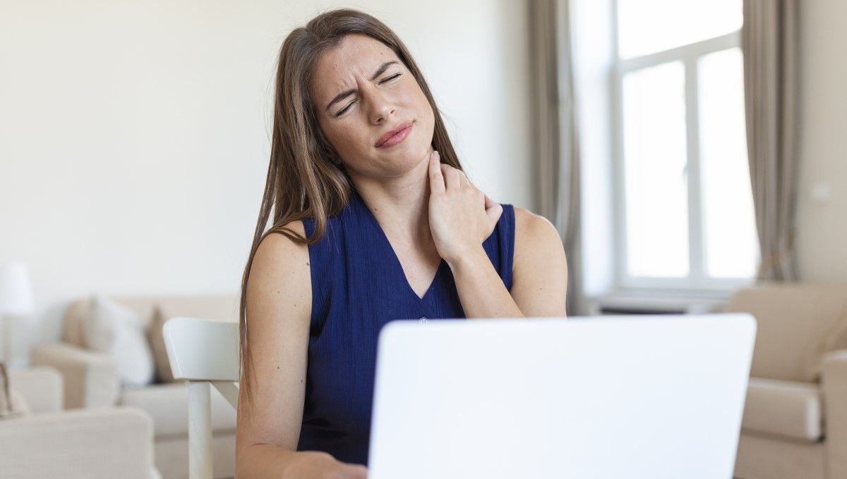 Mujer sufriendo de dolor de cuello mientras usa su ordenador (Foto. Freepik)