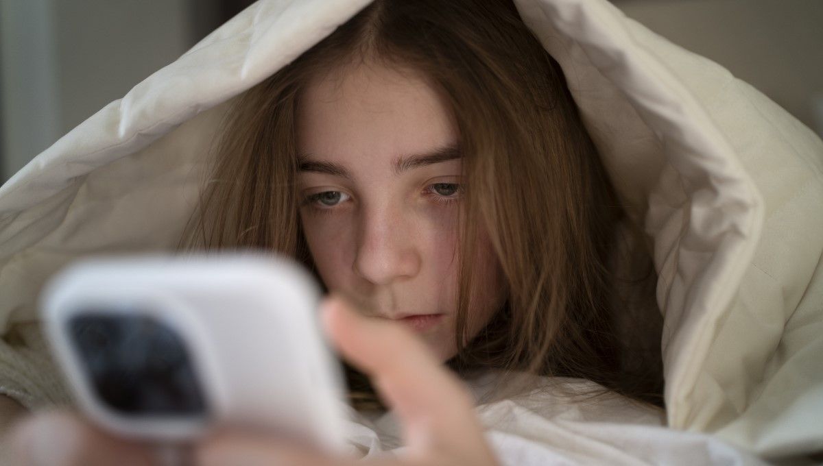 Joven adolescente usando el móvil en la cama (Foto. Freepik)