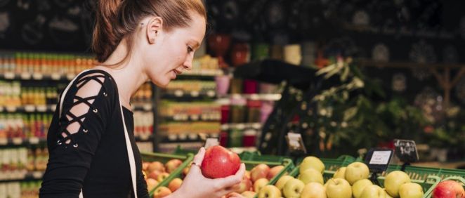 Mujer comprando manzanas en el supermercado (Foto. Freepik)