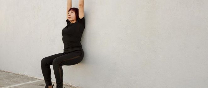 Mujer de mediana edad practicando una rutina fácil de pilates en pared para adelgazar (Foto. Freepik)