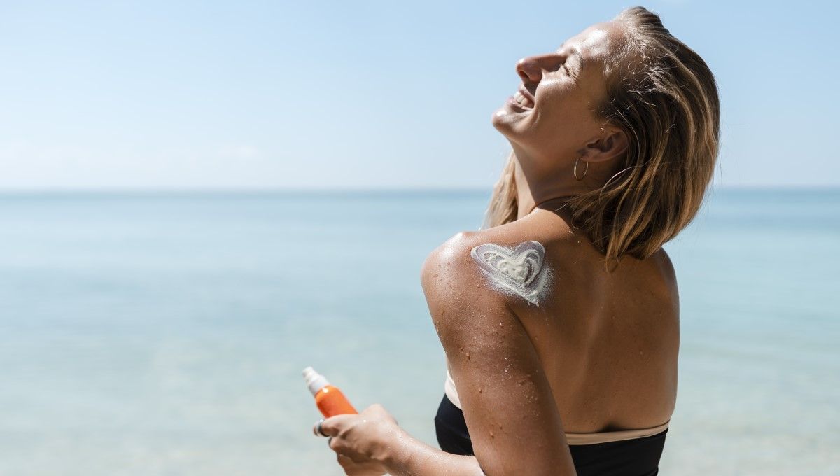 Mujer en la playa utilizando fotoprotectores solares (Foto. Freepik)
