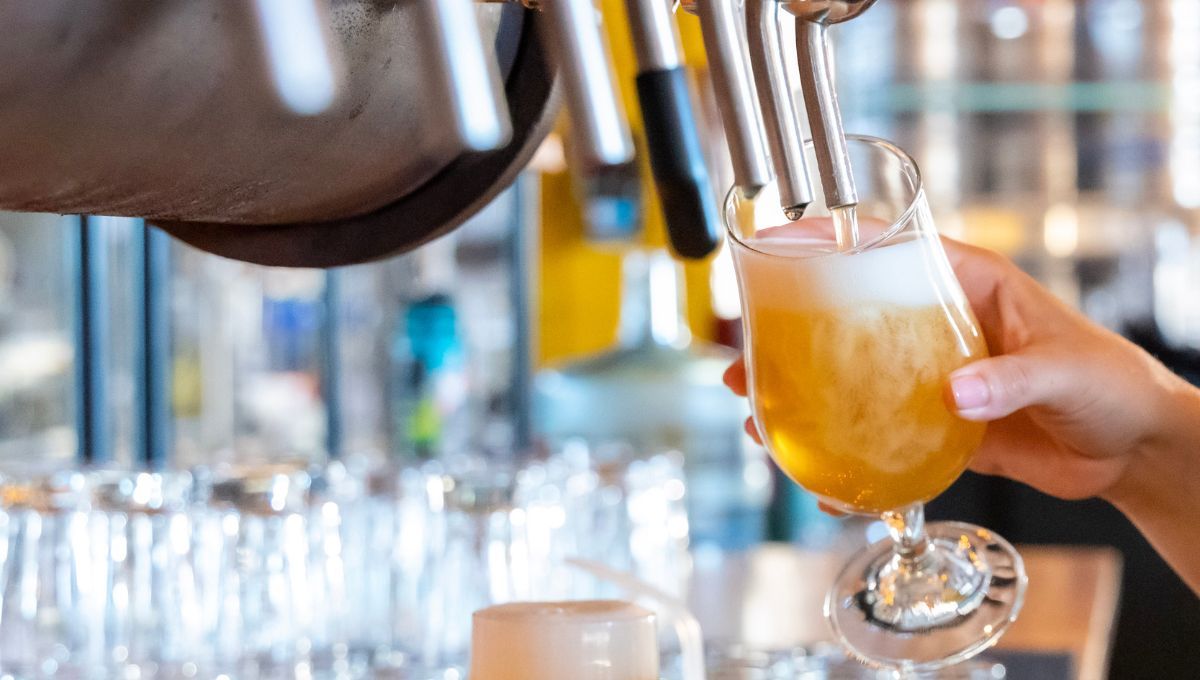 Persona sirviendo una cerveza o alcohol en un bar (Fuente: Canva)