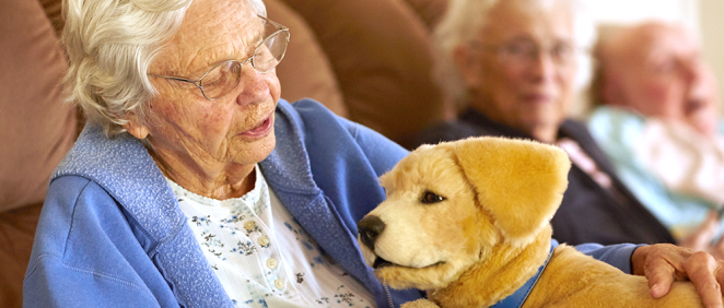 Anciana con demencia junto al perro robot (Foto: Tombot)