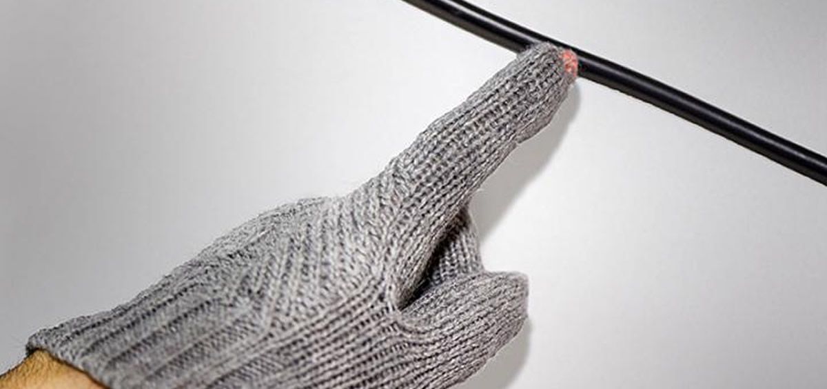 La yema del dedo de un guante de detección de voltaje inalámbrico se ilumina cuando la mano del usuario se acerca a un cable activo. (Foto. Universidad de Purdue)