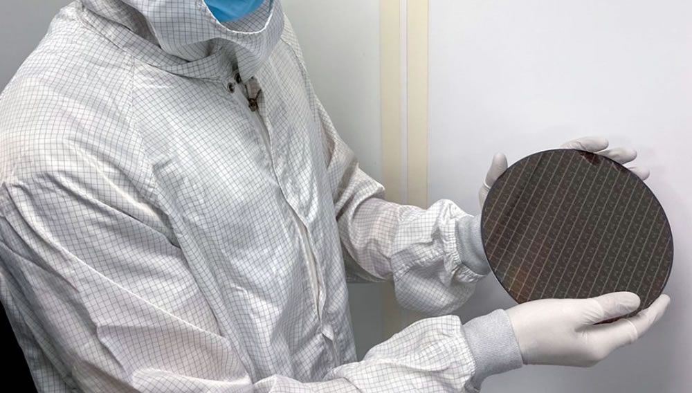 Uno de los investigadores muestras las obleas de silicio donde se contienen los cerebros robóticos (Foto. Universidad de Cornell)