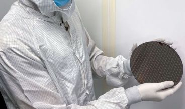 Uno de los investigadores muestras las obleas de silicio donde se contienen los cerebros robóticos (Foto. Universidad de Cornell)