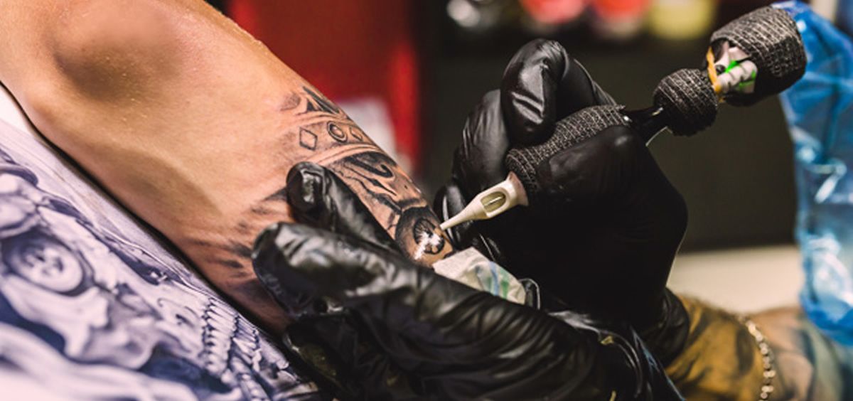 Persona realizando un tatuaje a otra (Freepik)
