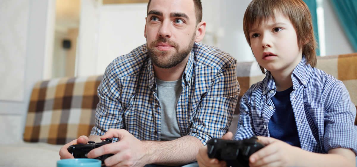 Niño jugando con su padre a los videojuegos (Foto. Freepik)