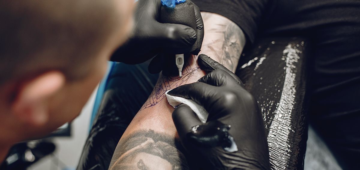 Hombre realizando un tatuaje (Foto: Freepik @prostooleh)