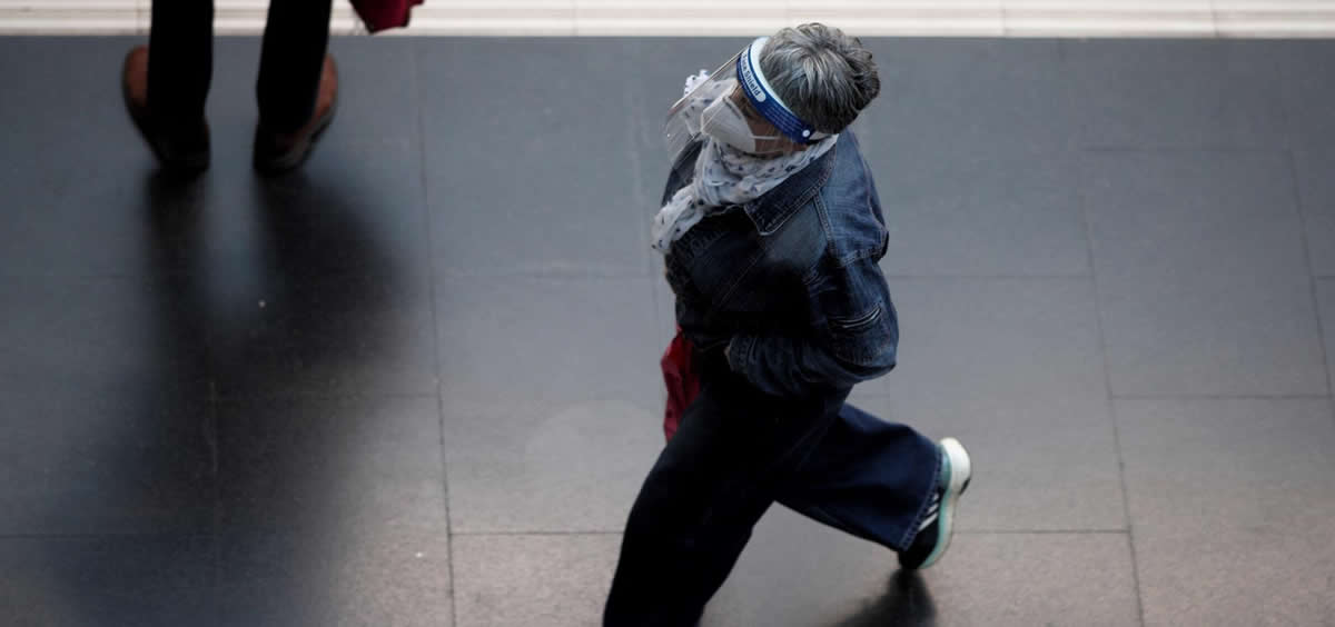 Una mujer protegida con pantalla protectora y mascarilla camina por un andén de la Estación de Príncipe Pío (Madrid) (Foto: Eduardo Parra - Europa Press)