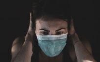Una mujer con mascarilla estresada por la pandemia. (Foto. Unsplash)
