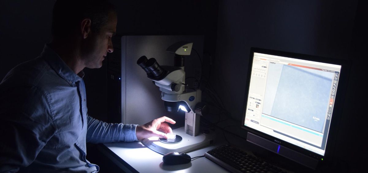 El investigador de la UPCT Javier Prior observando con una lupa de microscopio el diamante que utiliza para mejorar la resolución de las resonancias magnéticas (Foto. UPCT/EP)