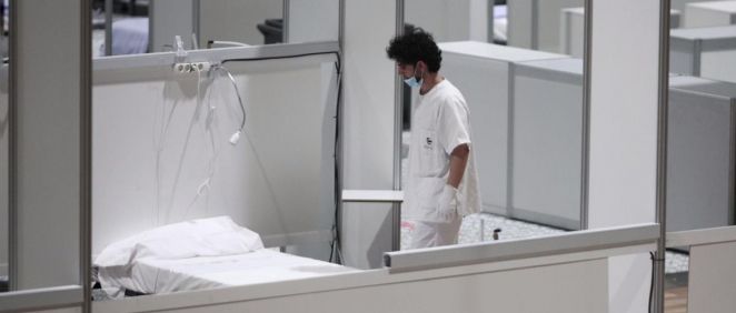 Un profesional sanitario frente a una cama vacía en el interior del hospital de campaña de IFEMA (Foto: Eduardo Parra - EP)