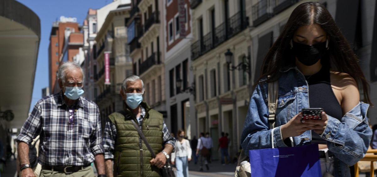 Varias personas pasean por las inmediaciones de la Puerta del Sol con mascarilla (Foto. Jesús Hellín  EP)