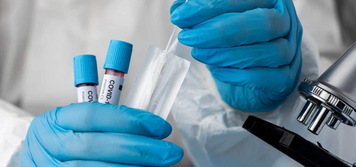 Profesional de laboratorio analizando muestras de sangre de pacientes COVID 19