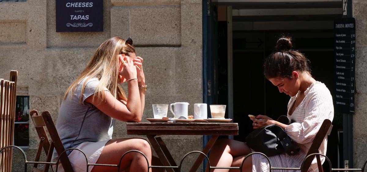 Dos mujeres en la terraza de un restaurante de la Rua da Raiña, en Santiago de Compostela (Foto. César Arxina. Europa Press)