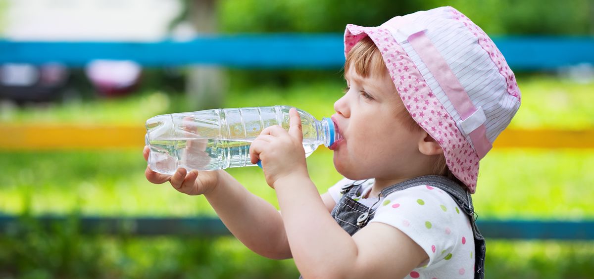Un niño pequeño bebe agua de una botella (Foto: Freepik)
