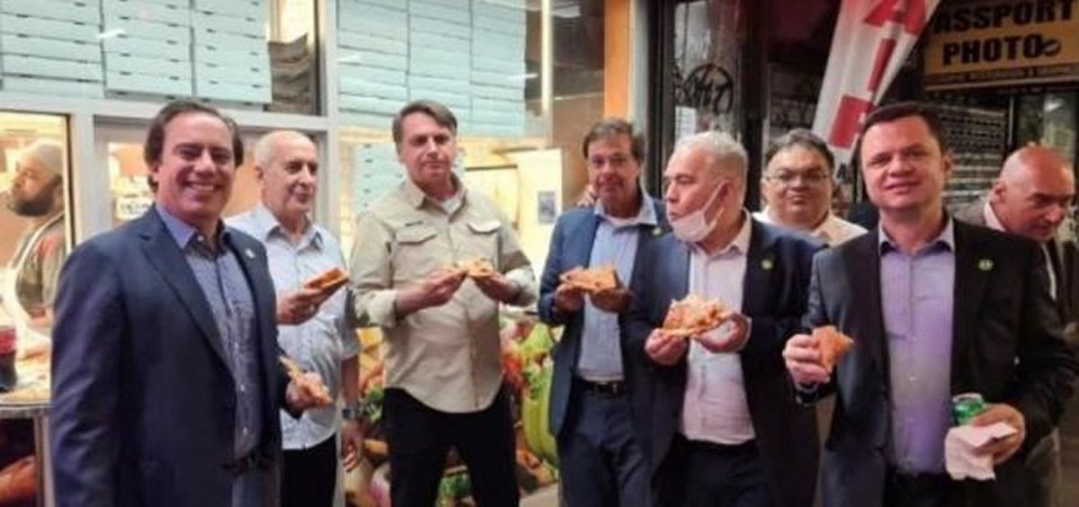 Jair Bolsonaro comiendo pizza con el presidente del Banco Federal de Caixa Económica, Pedro Guimaraes, y varios ministros en Nueva York (Foto. @GILSONMACHADONETO / Reuters)