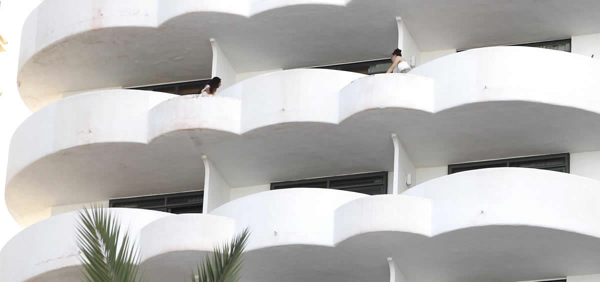Dos jóvenes en un balcón del hotel Palma Bellver, donde estaban confinados los estudiantes (Foto: Isaac Buj/EP)