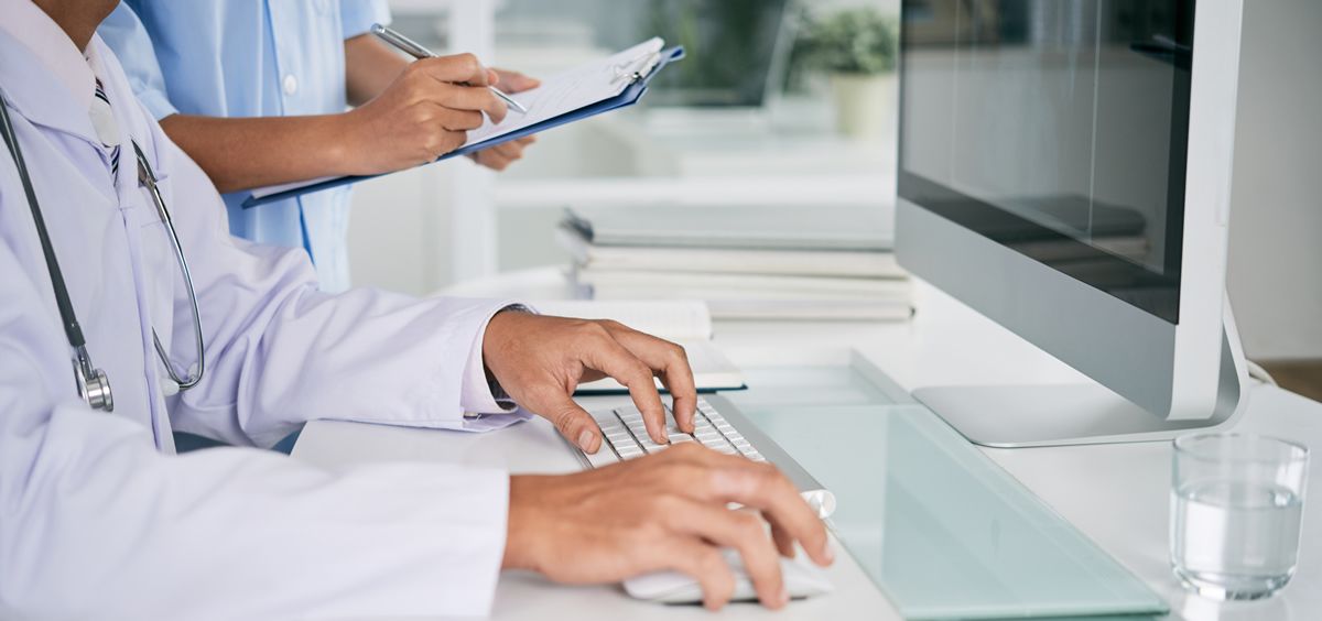 Un médico trabajando en consulta con un ordenador (Foto: Freepik)
