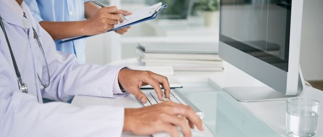 Un médico trabajando en consulta con un ordenador (Foto: Freepik)
