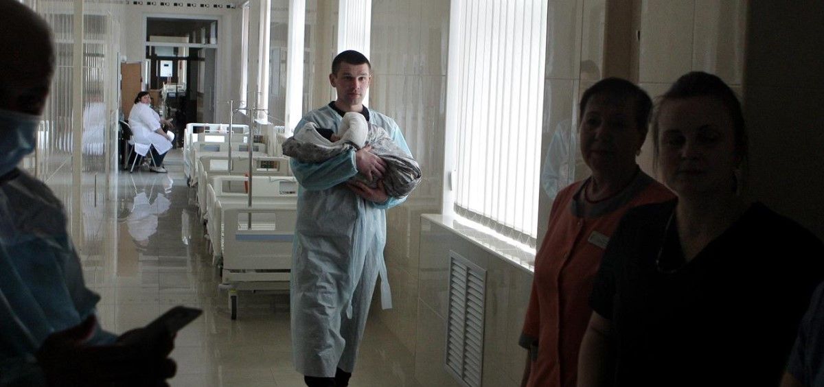 Un sanitario lleva a un bebé recién nacido en brazos en un hospital que se encuentra bajo ley marcial tras la invasión de Rusia, a ocho de marzo de 2022, en Kiev. (Foto. Ukrinform dpa Ukrinform)