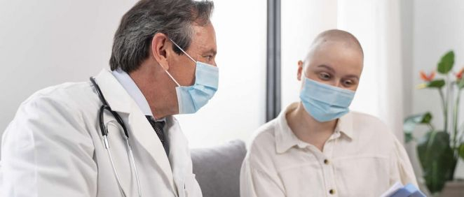 Una mujer con cáncer junto a un doctor, en consulta (Foto. Freppik)