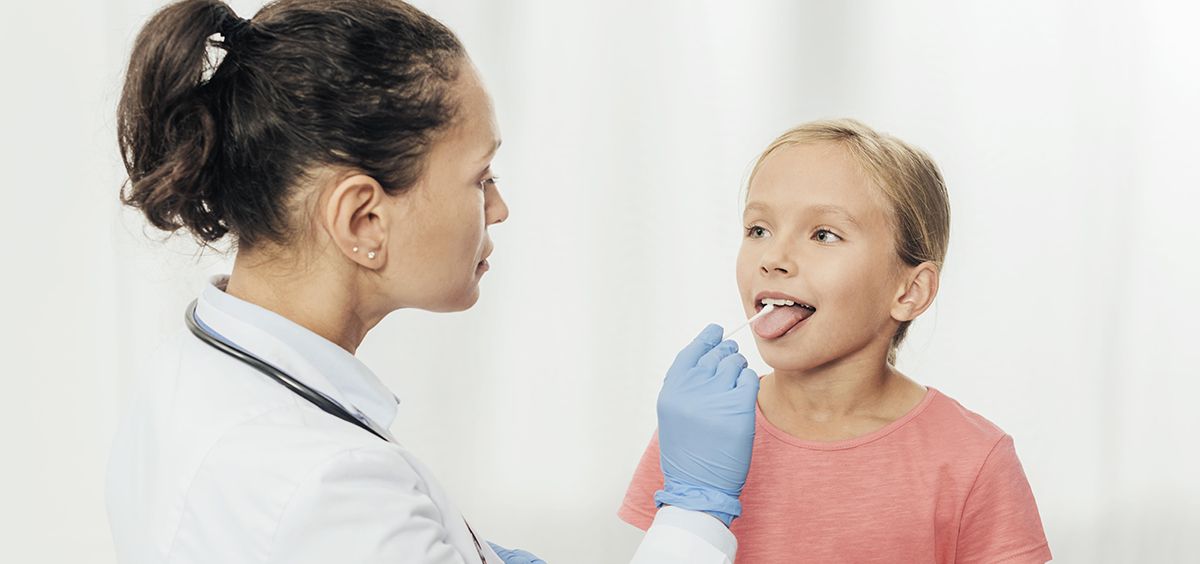 Doctora con niña mirándole la boca (Foto. Freepik)
