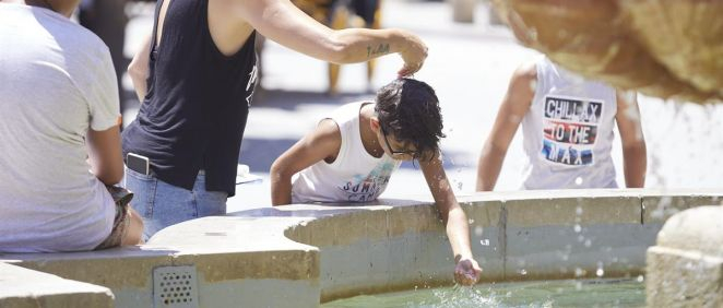 Una madre le echa agua a su hijo por la cabeza durante una ola de calor en Sevilla (Foto: Joaquín Corchero / EP)