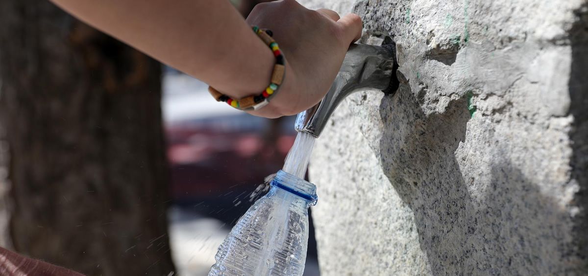 Una mujer rellena una botella de agua en una fuente, (Foto. Jesus Hellín, Europa Press)