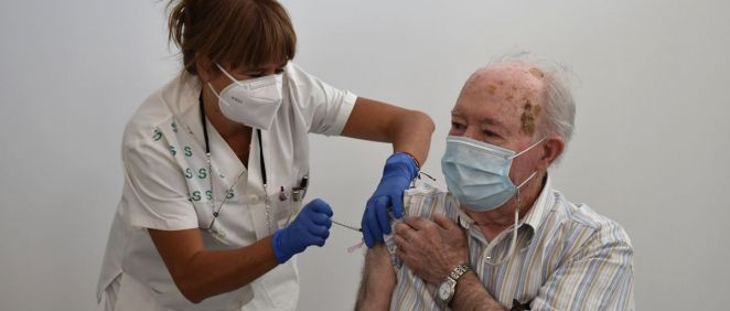Una profesional sanitaria administra la vacuna de la gripe a una persona mayor (Foto: M. Sanidad)