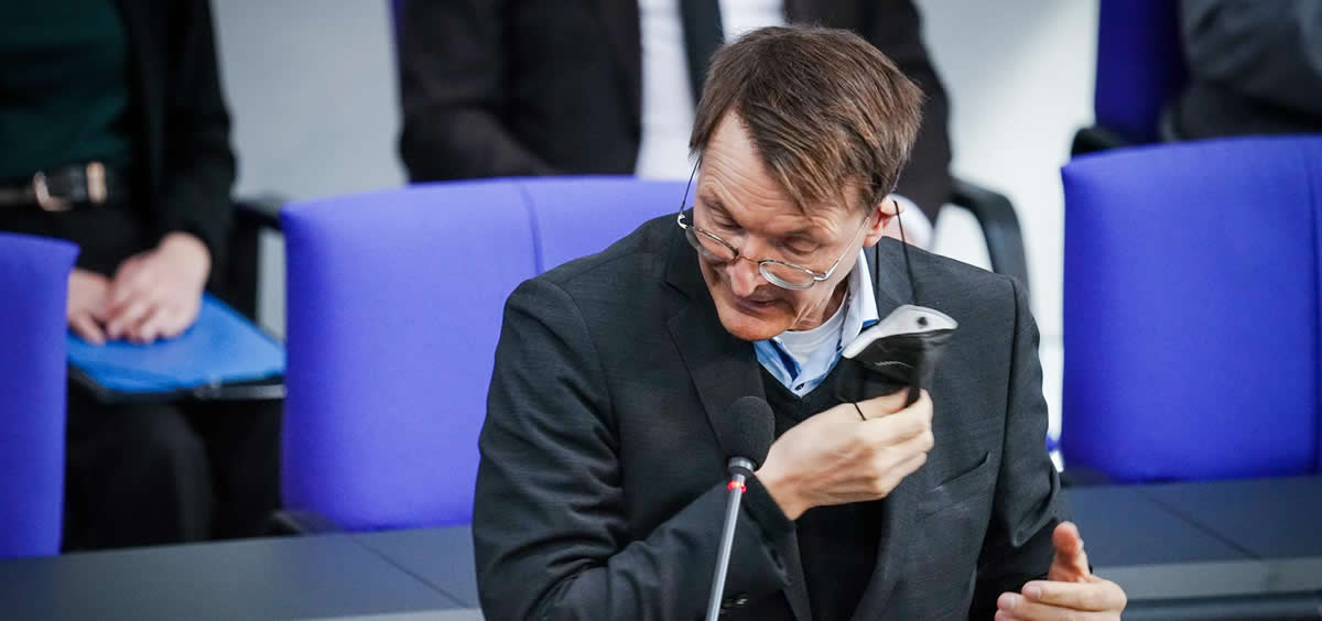 El ministro de Salud alemán, Karl Lauterbach, quitándose una mascarilla  (Foto: Kay Nietfeld/dpa)