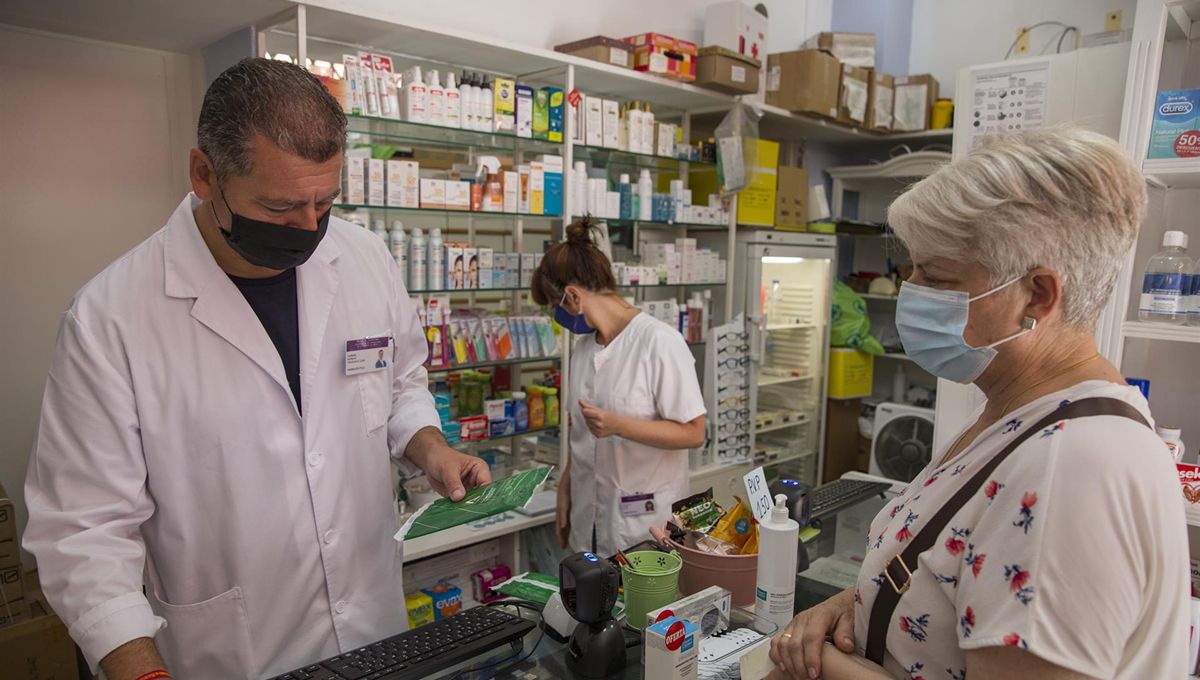 Profesionales y usuarios con mascarilla en una farmacia (Foto. Europa Press)