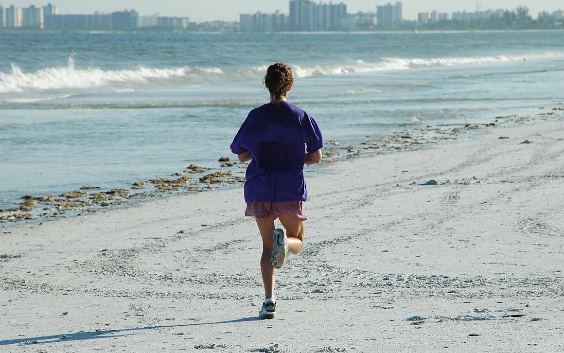 Una mujer practica running en una localidad costera