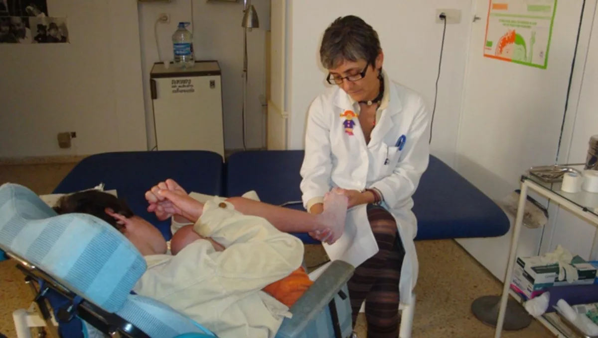 Una enfermera escolar cura una herida en el pie de un alumno (FOTO: CECOVA)