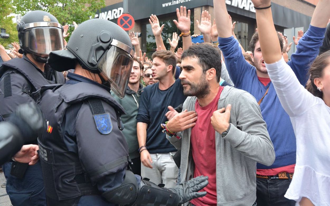 Un agente de la Unidad de Intervención Policial conversa con un ciudadano durante la jornada del 1 O en Cataluña | Foto: Policía Nacional