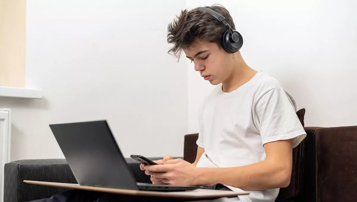 Niño de 16 años con el ordenador y el móvil. (Foto: Freepik)