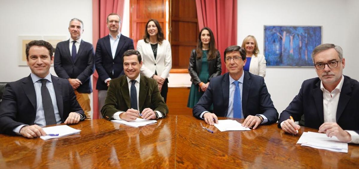 Juanma Moreno (PP) y Juan Marín (C's), en el centro de la imagen, firman el acuerdo para la investidura en Andalucía.